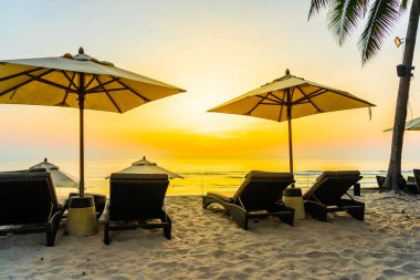 Şemsiye ve güzel plaj ve deniz gündoğumu, sandalyeye tim