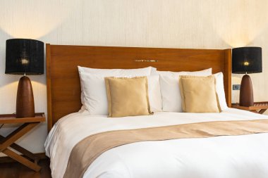 Yatak üzerinde güzel konforlu lüks beyaz yastık ve battaniye Dec