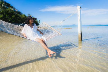 Portre güzel genç Asyalı kadın etrafında hamak üzerinde oturuyor s