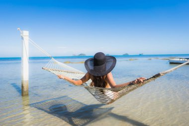 Portre güzel genç Asyalı kadın etrafında hamak üzerinde oturuyor s