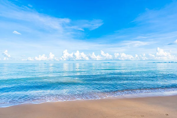 Hermosa playa tropical mar océano con nubes blancas cielo azul y — Foto de Stock
