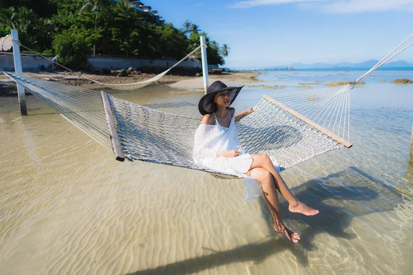 Portre güzel genç Asyalı kadın etrafında hamak üzerinde oturuyor s