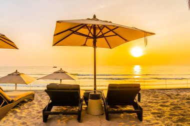 Şemsiye ve güzel plaj ve deniz gündoğumu, sandalyeye tim