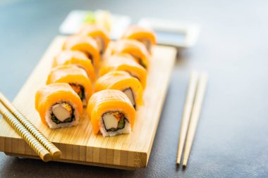 Somon Balık et suşi roll maki ahşap plaka üzerinde