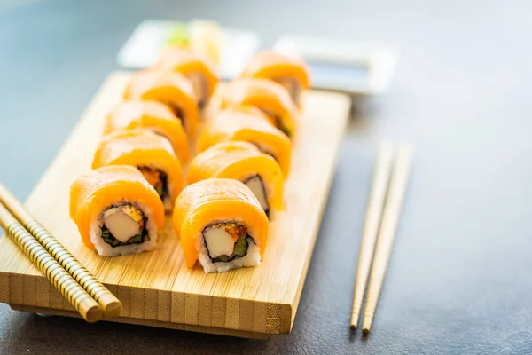 Salmón pescado carne sushi roll maki en placa de madera —  Fotos de Stock