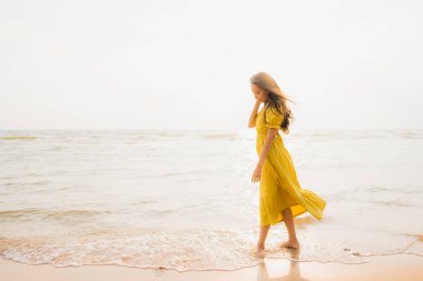 Portre güzel genç Asyalı kadın yürüyüş üzerinde plaj ve deniz o