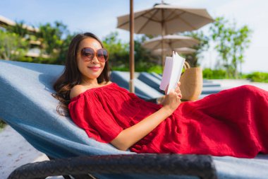 Portre güzel genç Asya kadın okuma kitap içinde yüzme Po