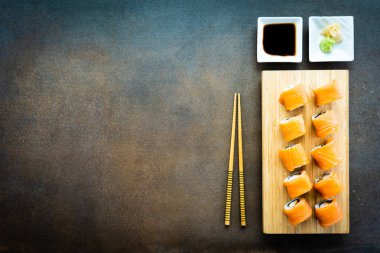 Somon Balık et suşi roll maki ahşap plaka üzerinde