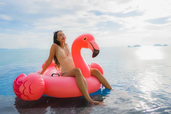 Portré fiatal ázsiai nő a felfújható úszó flamingó körül o — Stock Fotó