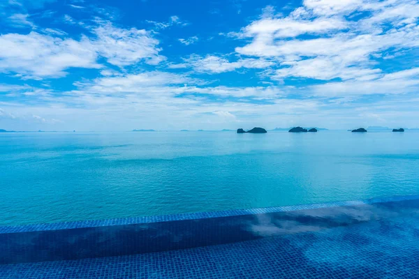 Beautiful outdoor swimming pool with sea ocean on white cloud bl — Stock Photo, Image