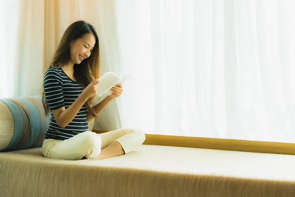 Porträt schöne junge asiatische Frau liest Buch in auf Sofa in — Stockfoto