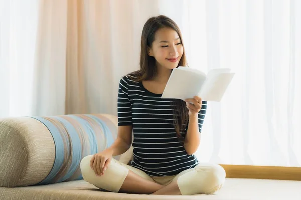 Ritratto bella giovane donna asiatica lettura libro su divano in — Foto Stock