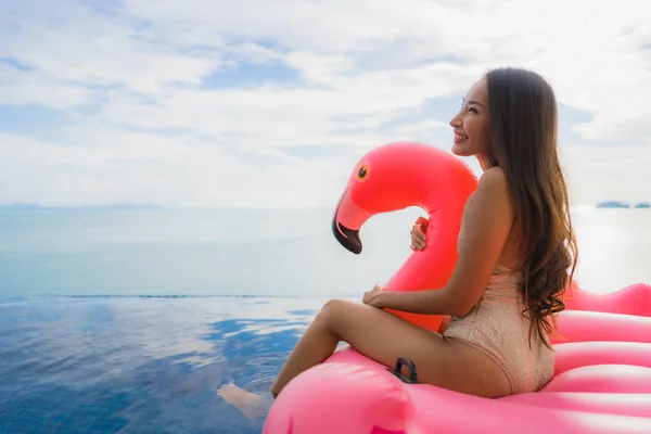 Portret jonge Aziatische vrouw op opblaasbare float Flamingo rond o — Stockfoto