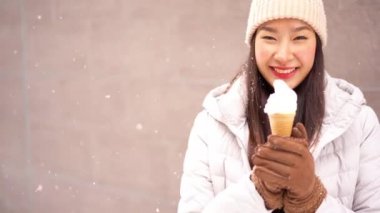 Güzel Asyalı kadının kışın dondurma tutarken ki görüntüleri.