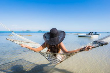 Portre güzel genç Asyalı kadın etrafında hamak üzerinde oturuyor s