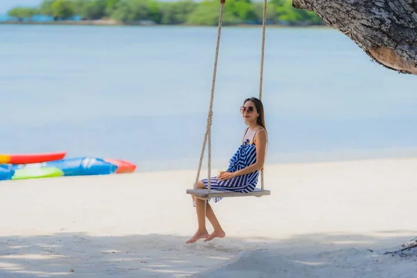 Ritratto giovane donna asiatica seduta su corda swing e mare intorno — Foto Stock