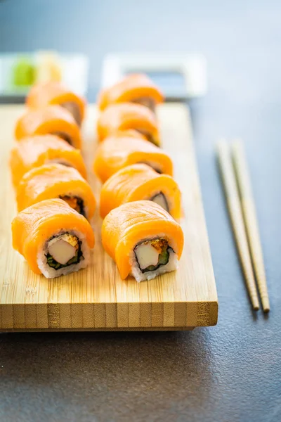 Somon Balık et suşi roll maki ahşap plaka üzerinde