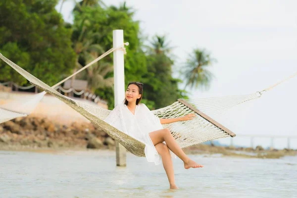 Portrét krásná mladá asijská žena sedící na houpací síti kolem s — Stock fotografie