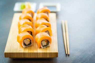 Somon Balık et suşi roll maki ahşap plaka üzerinde