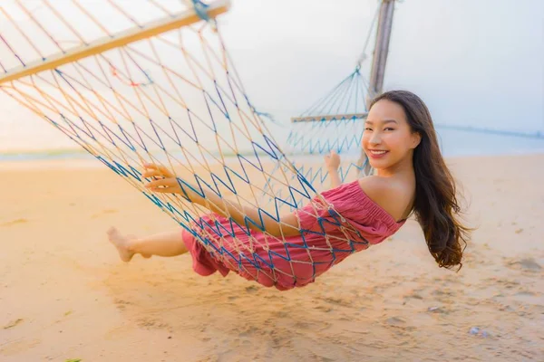 Porträt schöne junge asiatische Frau sitzt auf der Hängematte mit — Stockfoto