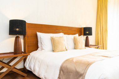 Yatak üzerinde güzel konforlu lüks beyaz yastık ve battaniye Dec