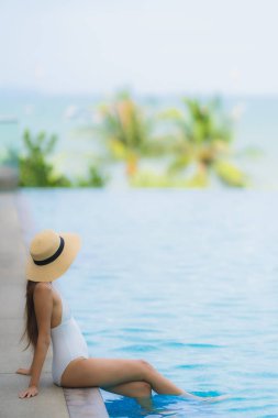 Portre genç asya kadın mutlu gülümseme yüzme kaka etrafında dinlenmek