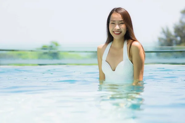 Beautiful young asian woman happy and smile in swimming pool for — Stock Photo, Image