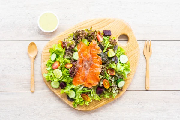 Raw Smoked salmon meat fish with fresh green vegetable salad