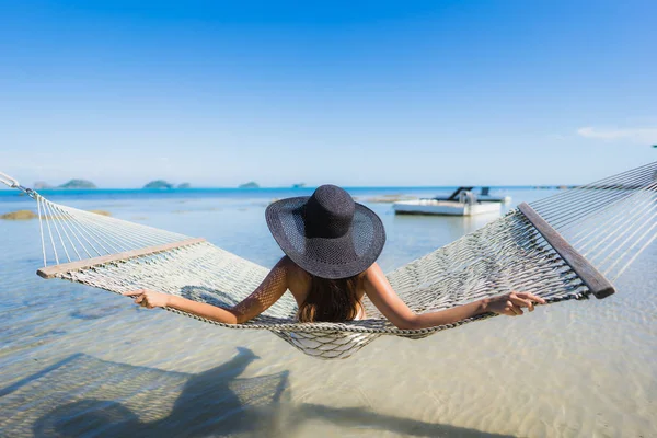 Portre güzel genç Asyalı kadın etrafında hamak üzerinde oturuyor s