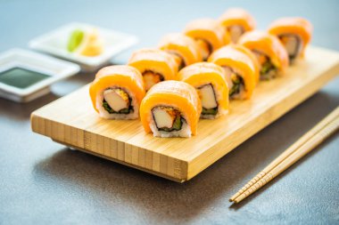 Somon Balık et suşi roll maki ahşap plaka üzerinde