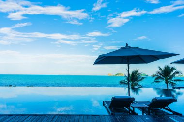 Şemsiye ve güzel lüks açık yüzme havuzu etrafında sandalye