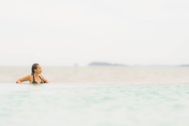 Portre güzel genç Asyalı kadın yüzme etrafında bikini giymek