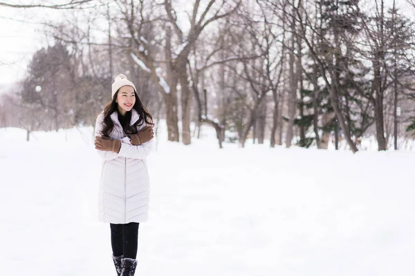 Schöne junge asiatische Frau lächelt glücklich für Reisen im Schnee gewinnen — Stockfoto