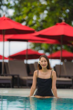 Portre genç asyalı kadın rahatla gülümseme açık yüzmek etrafında mutlu