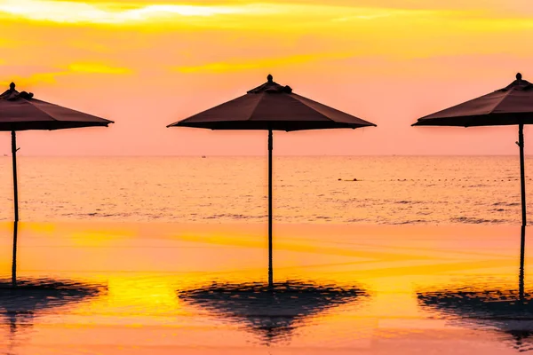 Şemsiye ve sandalye yüzme havuzu yakınında deniz okyanus plaj