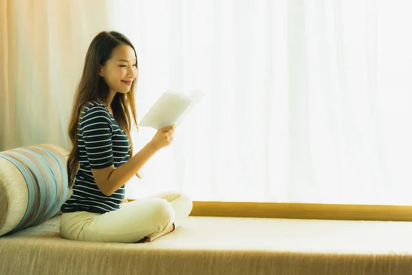 Portrét krásná mladá asijská žena, která četla knihu na pohovce v — Stock fotografie