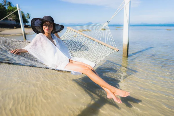 Portre güzel genç Asyalı kadın etrafında hamak üzerinde oturuyor s