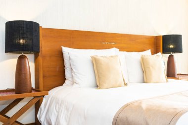 Yatak üzerinde güzel konforlu lüks beyaz yastık ve battaniye Dec