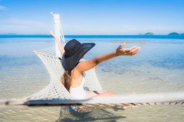 Portre güzel genç Asyalı kadın etrafında hamak üzerinde oturuyor s