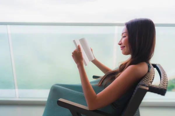 Hermoso retrato joven mujer asiática leyendo libro al aire libre ba —  Fotos de Stock