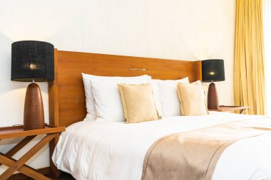 Yatak üzerinde güzel konforlu lüks beyaz yastık ve battaniye Dec