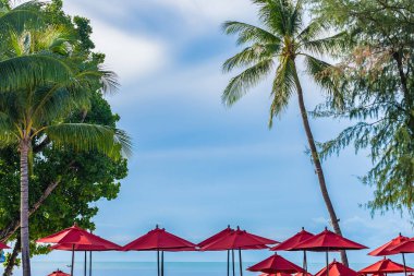 Sıcak açık yüzme havuzu etrafında güzel şemsiye ve sandalye