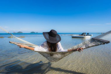 Portre güzel genç Asyalı kadın etrafında hamak üzerinde oturuyor s