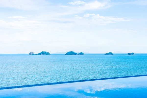 Beautiful outdoor swimming pool with sea ocean on white cloud bl — Stock Photo, Image