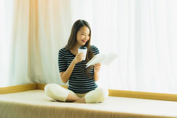 Retrato hermosa joven asiática mujer leyendo libro y celebrar café —  Fotos de Stock