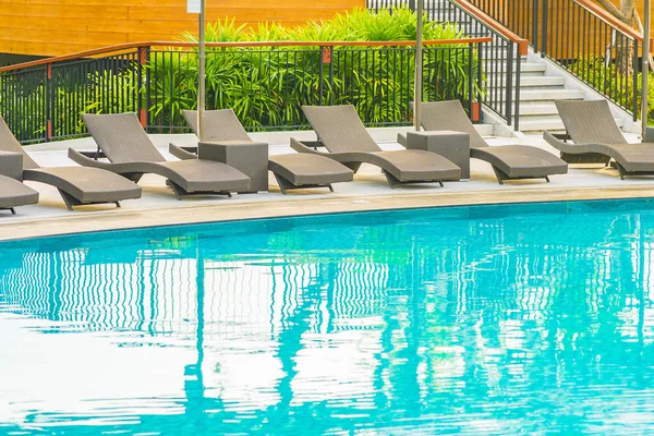 Otel re açık yüzme havuzu etrafında Şemsiye ve sandalye kanepe — Stok fotoğraf