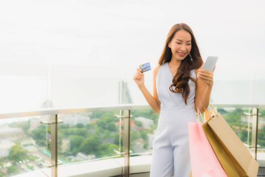 Portre güzel genç Asyalı kadın mutlu ve kredi ile gülümseme