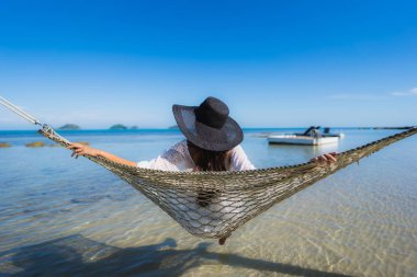 Portre güzel genç Asyalı kadın etrafında hamak üzerinde oturuyor s
