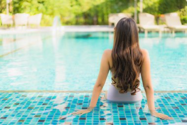 Portre güzel asya kadın mutlu gülümseme yüzme etrafında dinlenmek