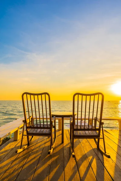 Puste drewniane krzesło i stół na odkrytym patio z pięknym tropi — Zdjęcie stockowe